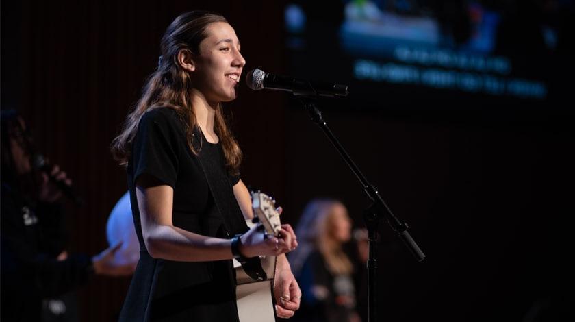 Maddie playing guitar on stage